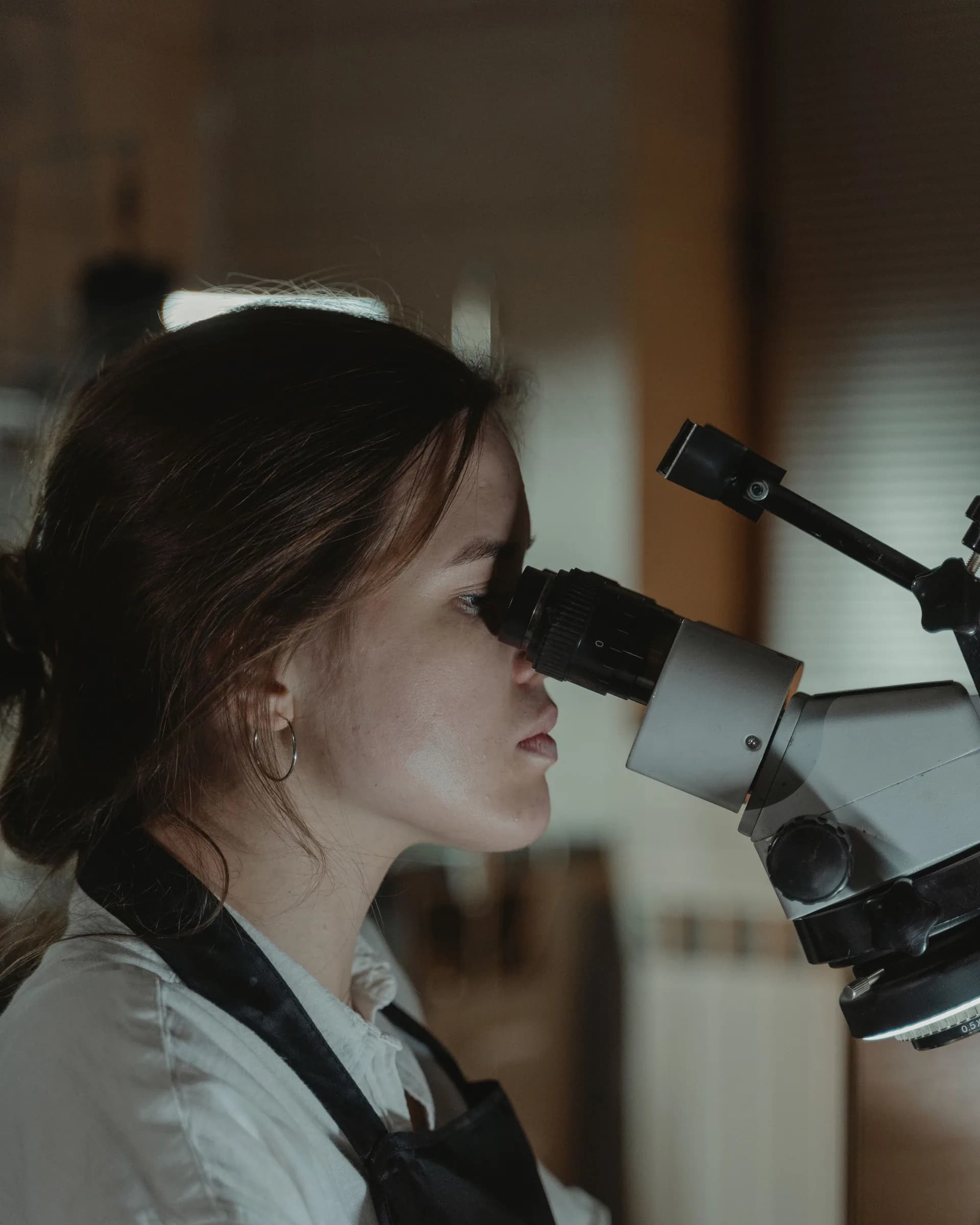 Profesional de laboratorio revisando una muestra por el microscopio
